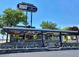 Exterior view of the Packing House restaurant and cocktail lounge with outdoor seating and hanging flower baskets.