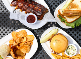 Assorted BBQ dishes on a patio table at Saz's State House Restaurant