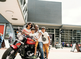 family of four on and around a Harley Davidson Motorcyle