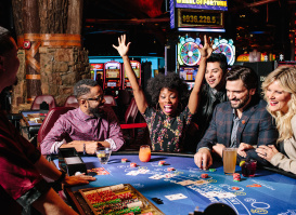 players gathered around table game while one cheers