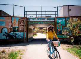 woman biking under Valley Passage Bridge