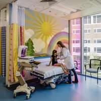Little girl getting treated at Shriner's hospital in a happy children's room.