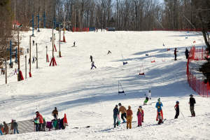 Kid's ski race on hill covered in snow in winter