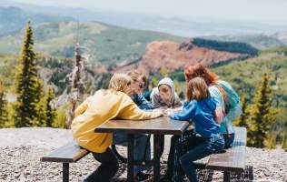 people sitting at picnic table outside  at brian head in the summer