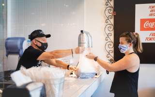 Man Handing Woman A Bag Of Food At Santo Taco in Salt Lake