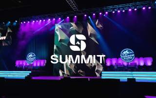 Stage setup with purple and blue lights, logos that say Silicon Slopes and a Summit Logo overlay
