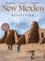 Cover of New Mexico Magazine, April 2026. Features ancient stone ruins of Chaco Canyon under a blue sky, with two people exploring.