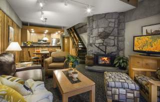 Living space of a room at Lodge at snowbird showing fireplace, arm chairs, and kitchenette