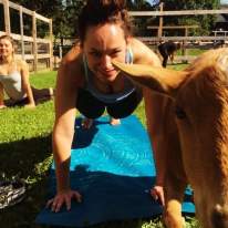 Young Female Planking on Yoga Mat with Goat Pictured Beside Her
