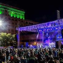 Night-time Photo of Syracuse Blues Fest Stage with People Crowded Around