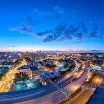 Night time view of interstate 81 from the roof of a tall building looking at a twilight blue sky, as the street lights turn on