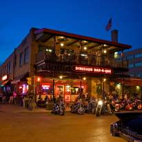 Outside of Dinosaur BBQ at Night with Motorcycles Parked In Front