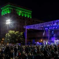Night-time Photo of Syracuse Blues Fest Stage with People Crowded Around