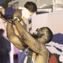 A dad lifts child at Taste of Syracuse
