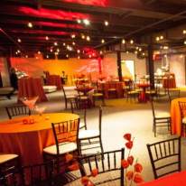 Elegant Sky Armory Room with Red and Orange Accents on Tables, Center Pieces and Lighting