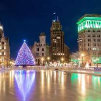 Evening photo of Clinton Square Ice Rink and Holiday Tree lit up in Syracuse, NY