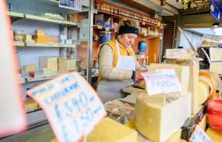 Stall holder at Bury Market with cheese in the foreground