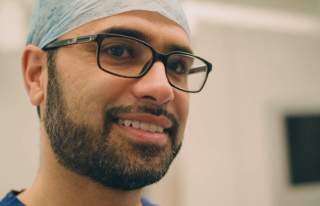 Dr Naseer Ahmad close up smiling in scrubs