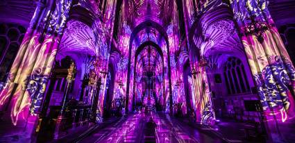 Luxmuralis light show of purple light and images on cathedral walls