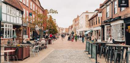 Pedestrian Street in Chichester lined with storefronts and restaurants with outdoor seating