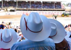 An audience wearing cowboy hats at the rodeo in Norco, CA