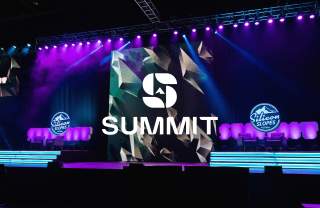 Stage setup with purple and blue lights, logos that say Silicon Slopes and a Summit Logo overlay