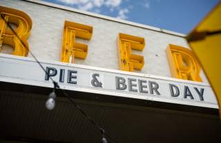 A store sign that says Beer with a marquee underneath that says Pie & Beer Day