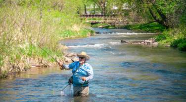 man fly fishing in the waters of rapid creek found in rapid city, sd