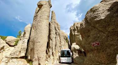 mt rushmore tours charter bus squeezing through the needles eye tunnel on needles highway in custer state park