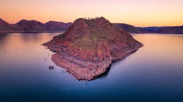 View of an island in Lake Argyle with a boat moored alongside.