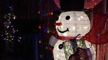 A happy snowman glows with festive lights in Overland Park