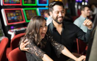 Couple playing slots at casino