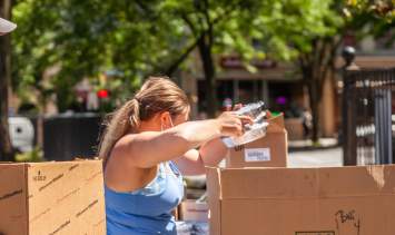 A woman is packing food into a box.