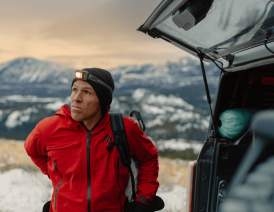 Aaron Mulkey in a red jacket and hat standing in the snow Cody Wyoming