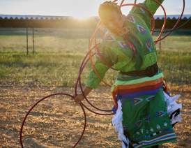 Woman dressed in regalia hoop dancing