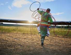 Women dressed in regalia with hoops hoop dancing