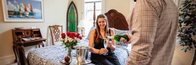 couple enjoying champagne on bed
