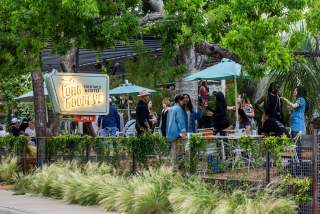 People hanging out drinking on the outdoor patio at the Long Goodbye.