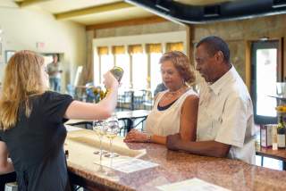 couple watching as woman pours samples of wine at Inwood Estates winery in Fredericksburg Texas