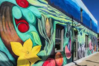 A mural of flowers, fruits, and veggies adorns the exterior of The Anchorage restaurant in Greenville, SC.