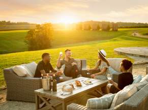Friends enjoying a Wine Tasting Stone Tower with the sunset in the distance