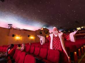Santa standing by the seat at the Plaza Theatre in Palm Springs