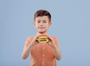 child boy with sandwich in hand. looks at the camera,