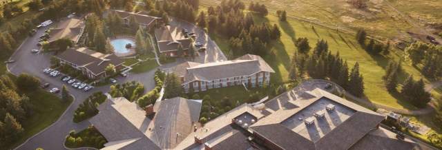 Aerial view of Little America Hotel and Resort with green grounds and pool.