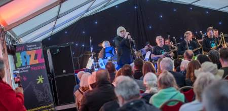 Sir Karl Jenkins singing on stage at Swansea Jazz Festival
