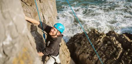 Man abseiling along coastal cliffs