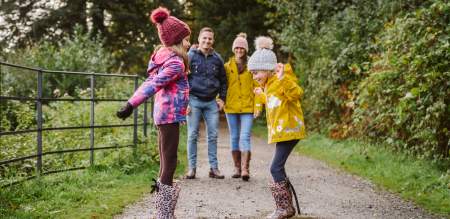 Family enjoying jumping in muddy puddles Penllergare
