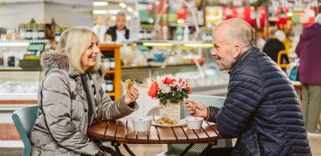 A couple enjoying food and drink at Swansea Market
