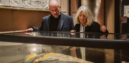 Couple looking through glass cabinet at mummy in swansea museum