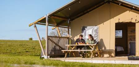 Couple sitting outside of a glamping pod having breakfast